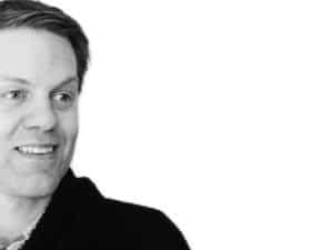 Portrait homme souriant, noir et blanc.