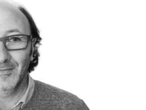 Portrait homme souriant, noir et blanc, flou artistique.